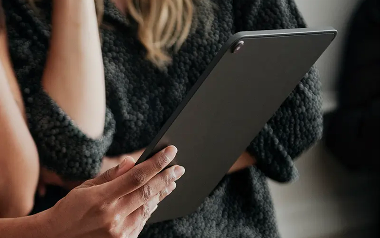 Person hält ein Tablet und informiert sich über ein Angebot